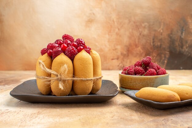 Side view of a gift cake fruit and biscuits on mixed color table