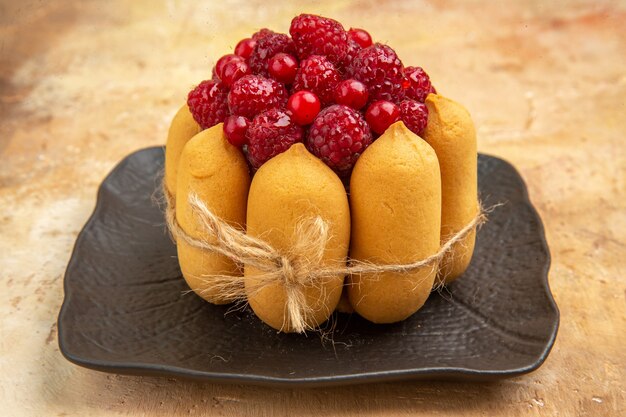 Side view of a gift cake with fruits on the mixed color table horizontal view