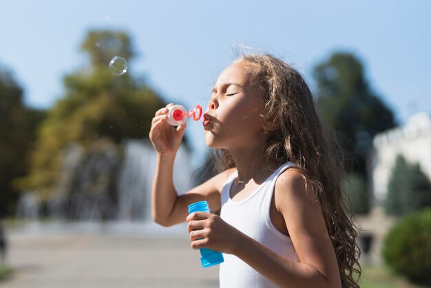 Side view of girl blowing bubbles