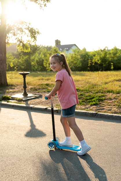 Side view of girl on blue scooter