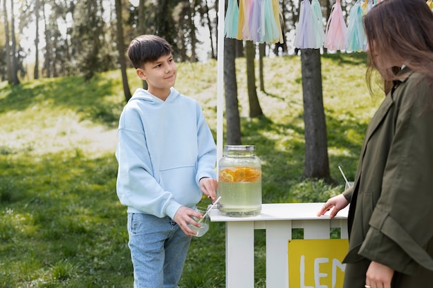 Side view girl buying lemonade