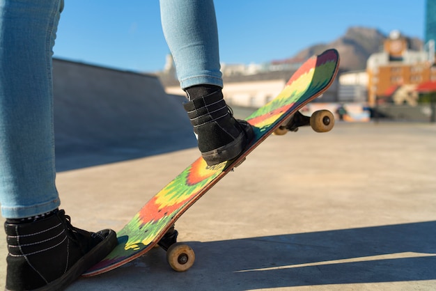 Ragazza di vista laterale su skateboard colorato