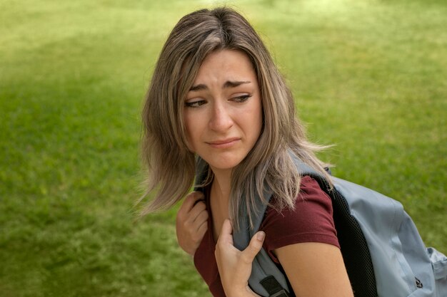 Вид сбоку девочка плачет на школьном дворе