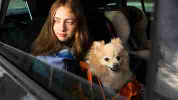 Free photo side view girl and dog in car