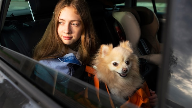 Боковой вид девушка и собака в машине