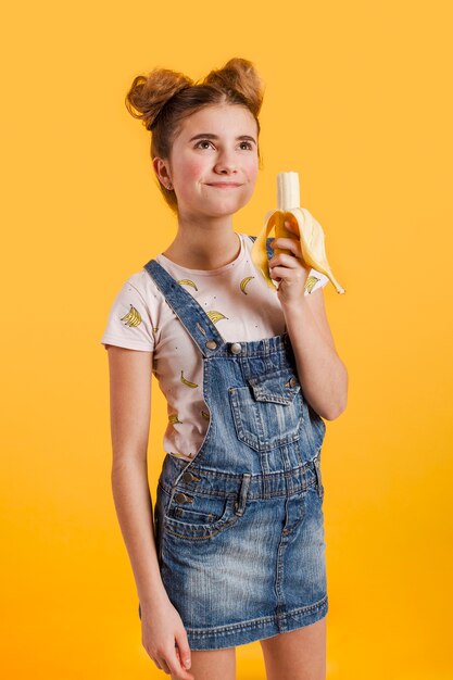 Вид сбоку девушка ест банан