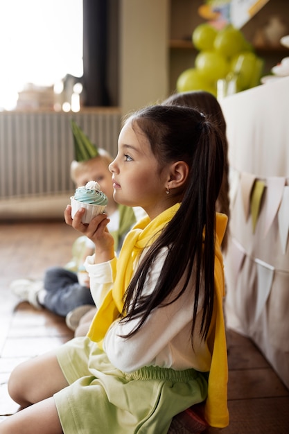 Side view girl holding cupcake