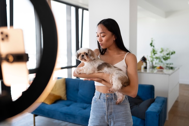 Foto gratuita cane della holding della ragazza di vista laterale