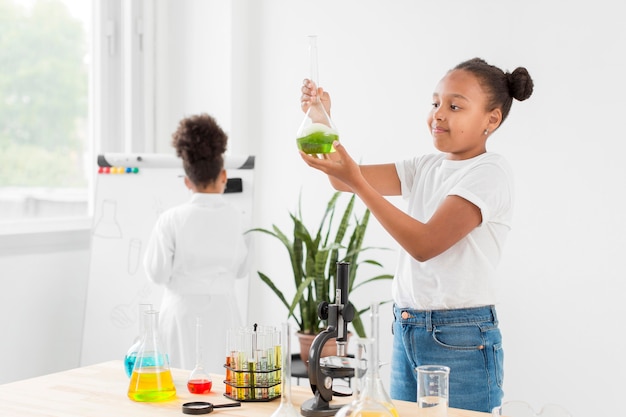 Side view of girl holding test tube with potion