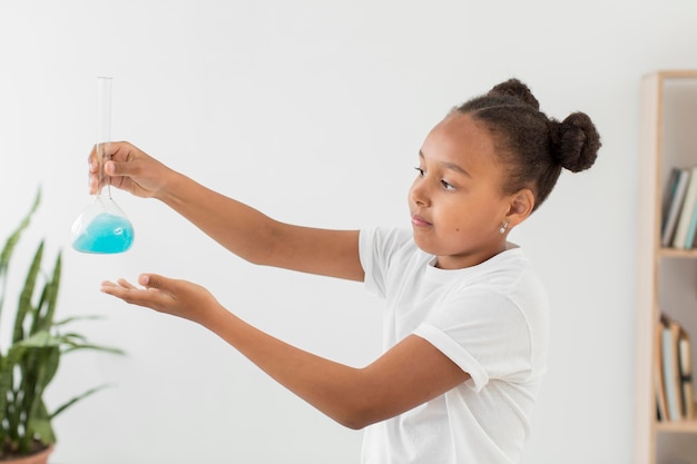 Free photo side view of girl holding tube with potion