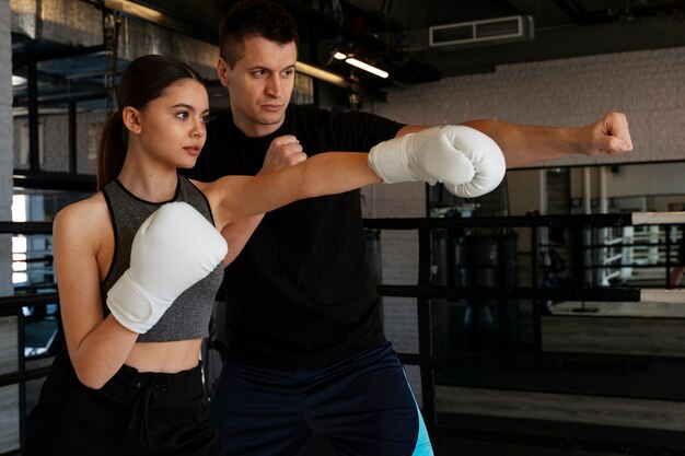 Foto gratuita ragazza di vista laterale che impara boxe