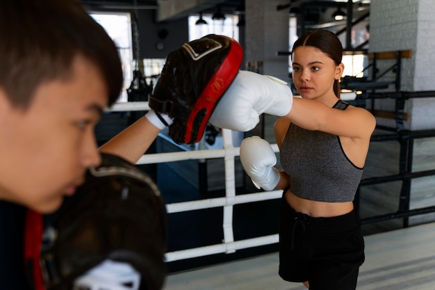 Вид сбоку девушка учится боксу
