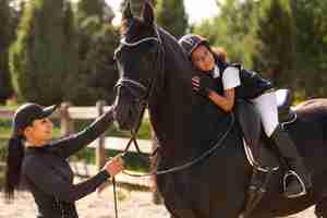 Foto gratuita ragazza di vista laterale che impara ad andare a cavallo