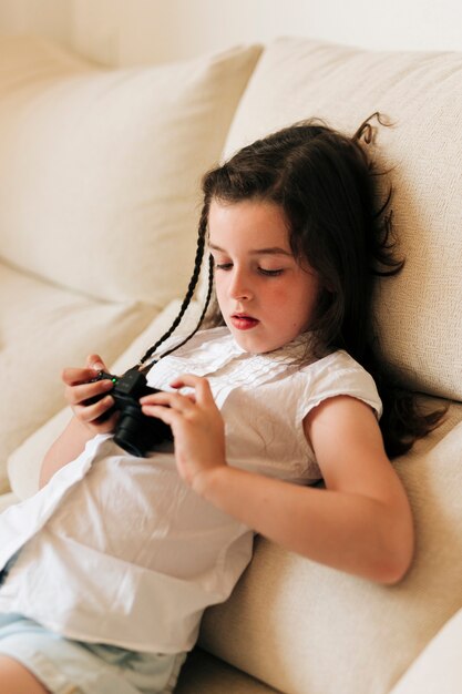 Side view girl looking at photos on the camera