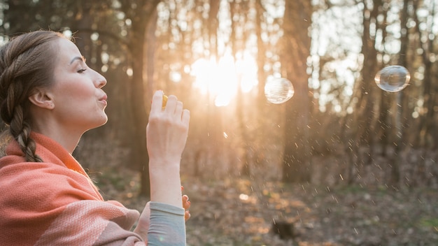 Foto gratuita ragazza di vista laterale che fa le bolle