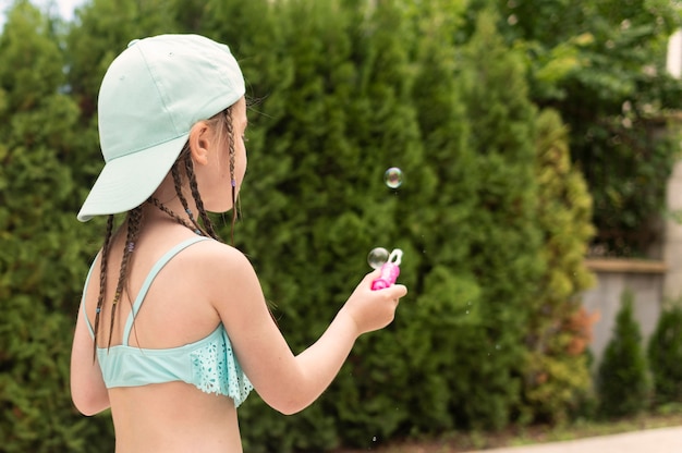 Free photo side view girl making soap bubbles