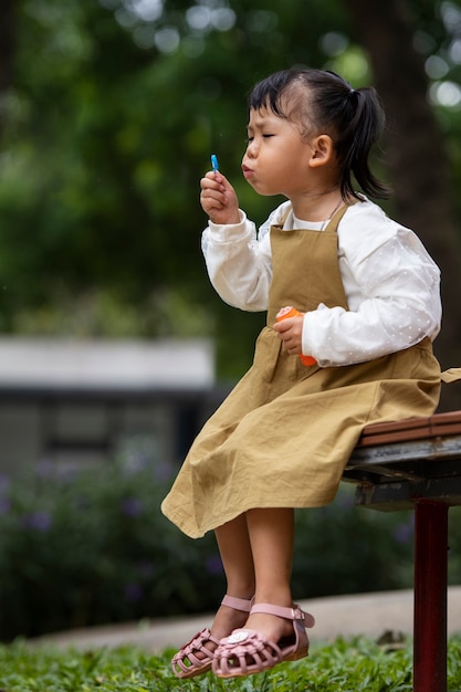 Free photo side view girl making soap bubbles