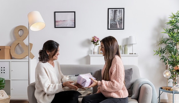 Side view girl offering gift to mom