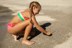 Free photo side view girl playing at the beach