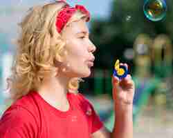 Free photo side view girl playing with bubble blower