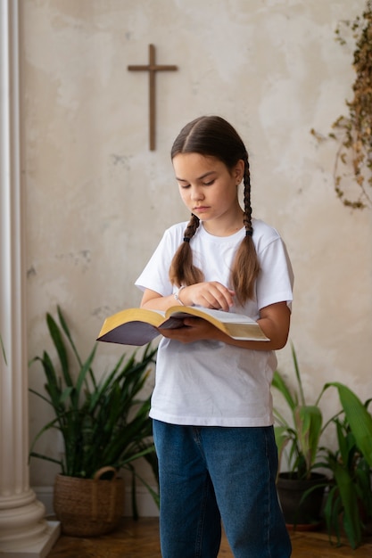 Вид сбоку девушка читает библию в воскресной школе