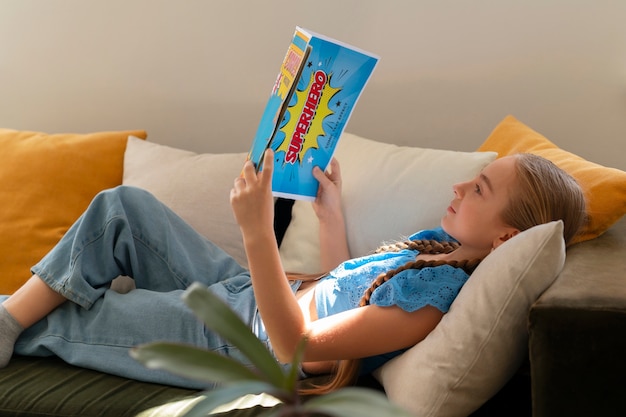 Free photo side view girl reading comics indoors