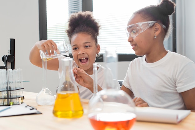 Side view of girl scientist at home with tubes