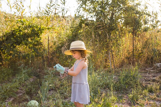 Side view of girl wearing gloves in the field