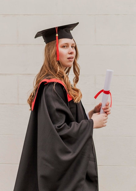 Бесплатное фото Боковой вид девушка с дипломом