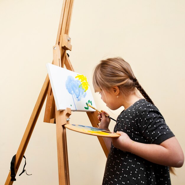Side view of girl with down syndrome painting with brush