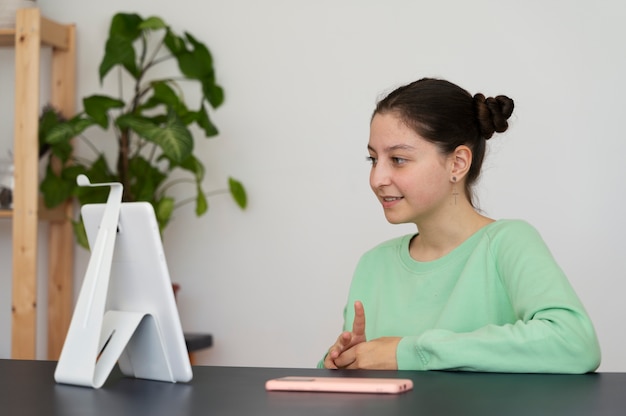 Side view girl with tablet at home