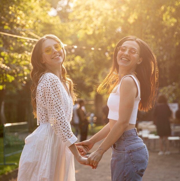 Side view girlfriends holding hands