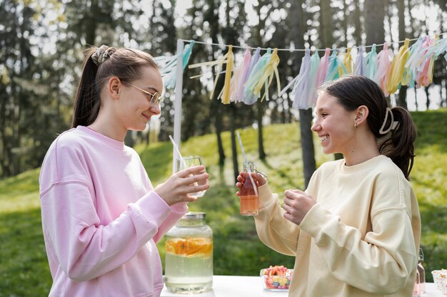 Side view girls drinking lemonade