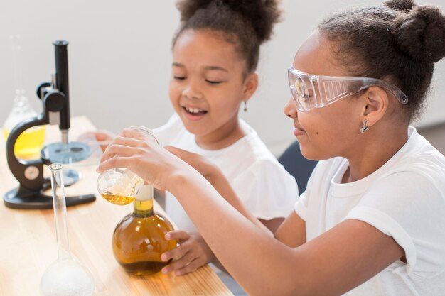 Side view of girls experiments chemistry at home