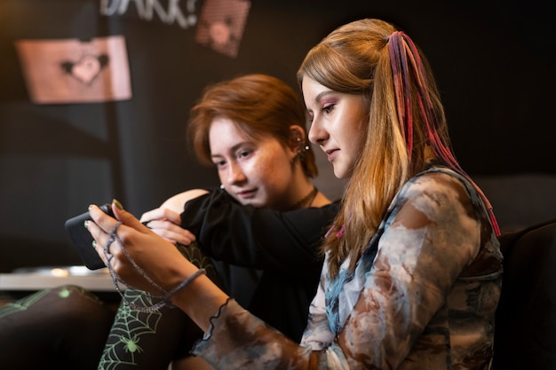 Free photo side view girls looking at smartphone