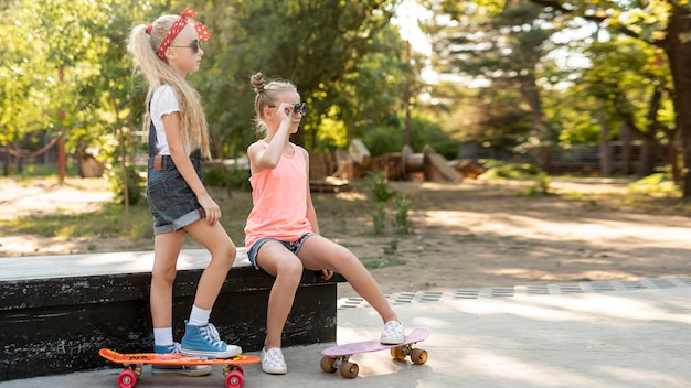 Free photo side view of girls with skateboards