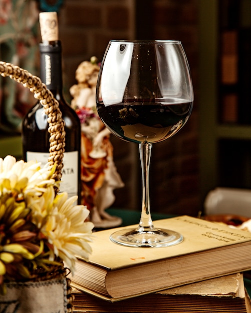 Side view of a glass of red wine on book