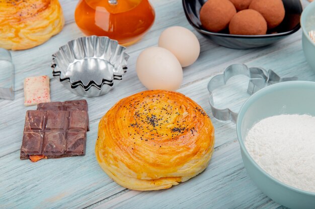 Side view of goghal with chocolate eggs flour sweets butter on wooden surface