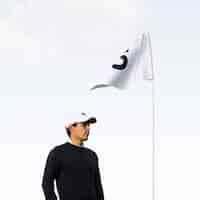 Free photo side view of golfer with flag