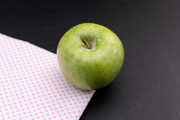 Side view green apple on black wooden