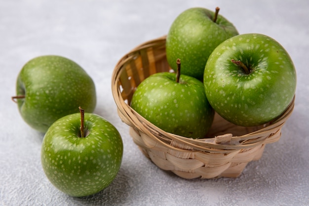 Side view green apples in a basket on a white background