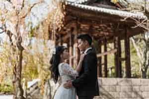 Free photo side view of groom and bride embraced outdoors