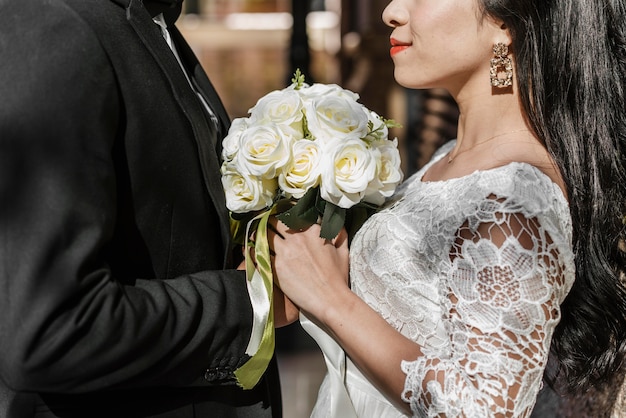 花の花束を保持している新郎と新婦の側面図