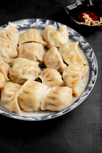 Side view of gyoza with soy sauce on a plate