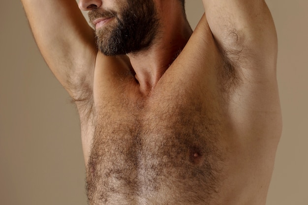 Free photo side view hairy man posing in studio