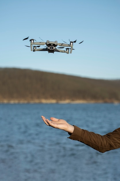 Foto gratuita vista laterale mano e drone all'aperto