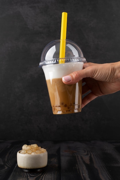 Side view hand holding bubble tea cup