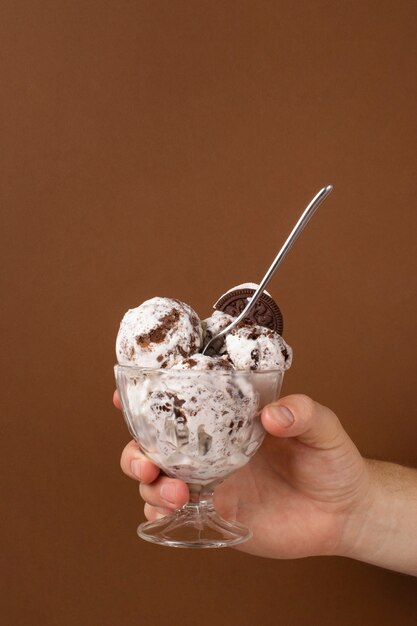 Side view hand holding cup with ice cream