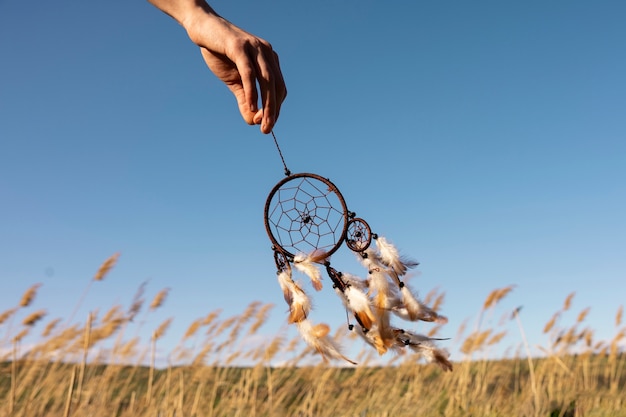 Free photo side view hand holding dream catcher