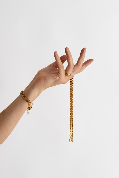 Side view hand holding gold chain